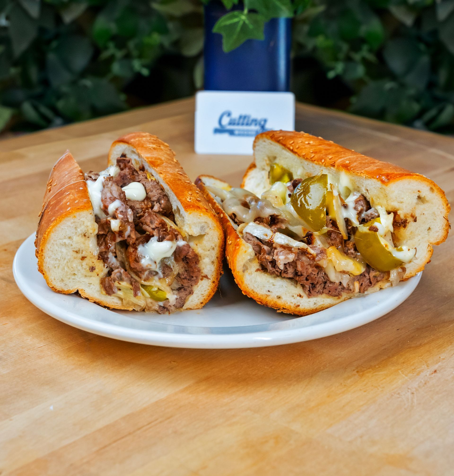 Two sandwiches are cut in half on a white plate