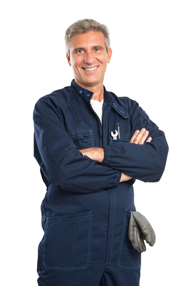 Operaio sorridente in tuta blu navy, a braccia conserte e con i guanti in mano, su sfondo bianco