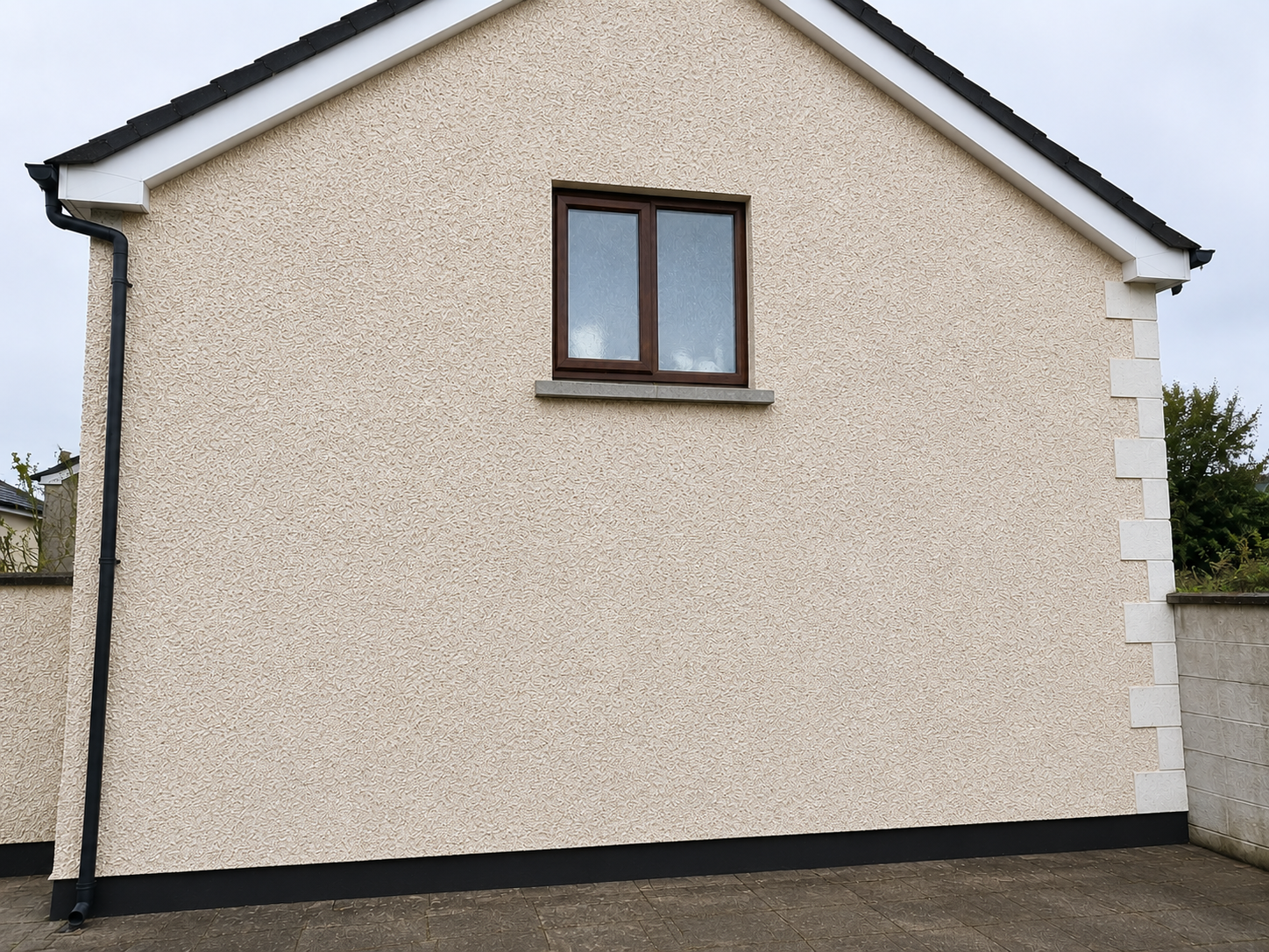 Front of a cream-colored house with a single upstairs window and dark trim