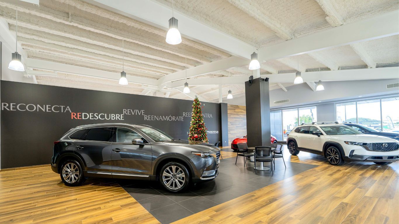 Two cars are parked in Flagship Mazda, Jeep & Chrysler showroom.
