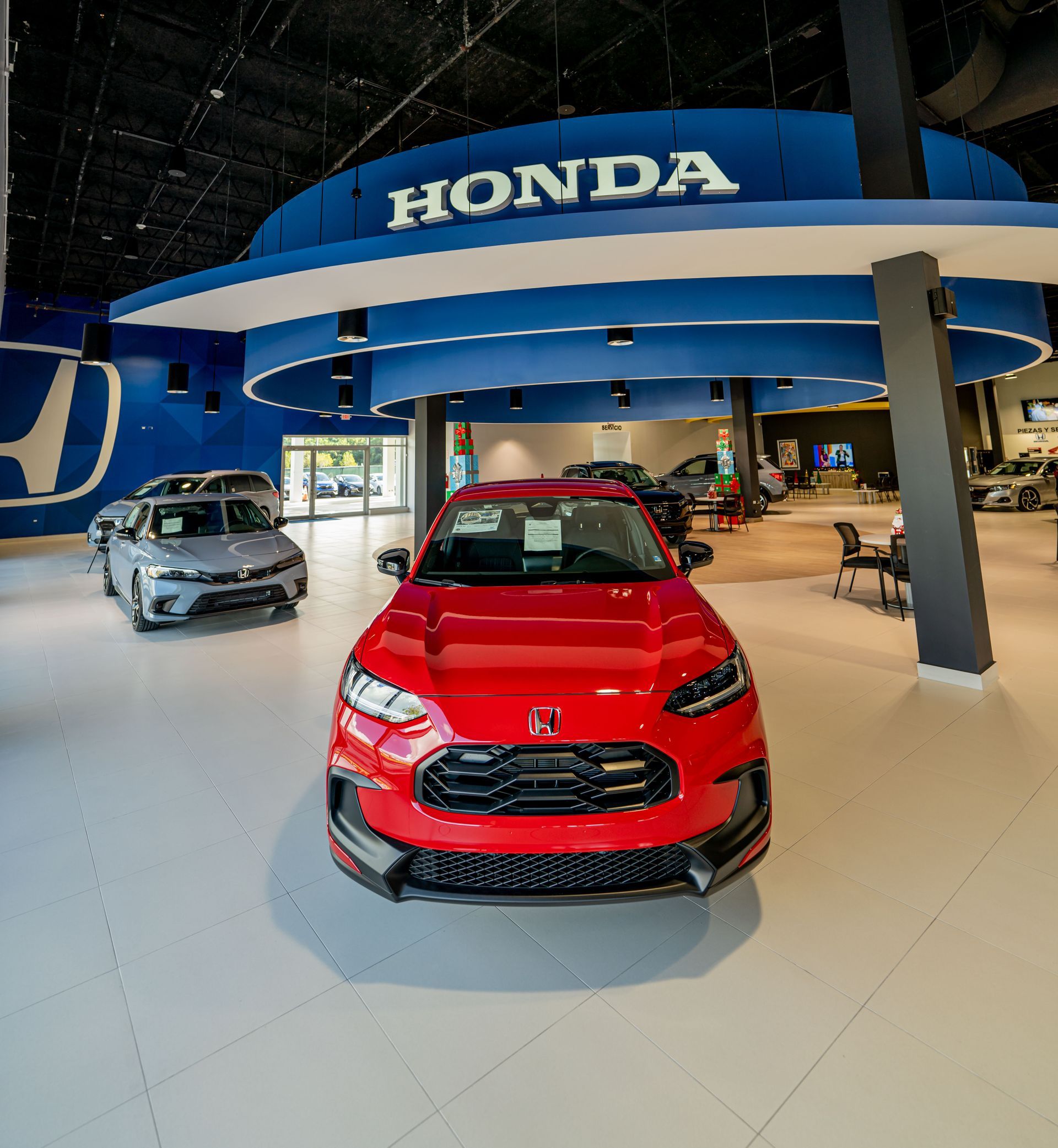 A red honda car is parked in a honda showroom built by DEV Builders