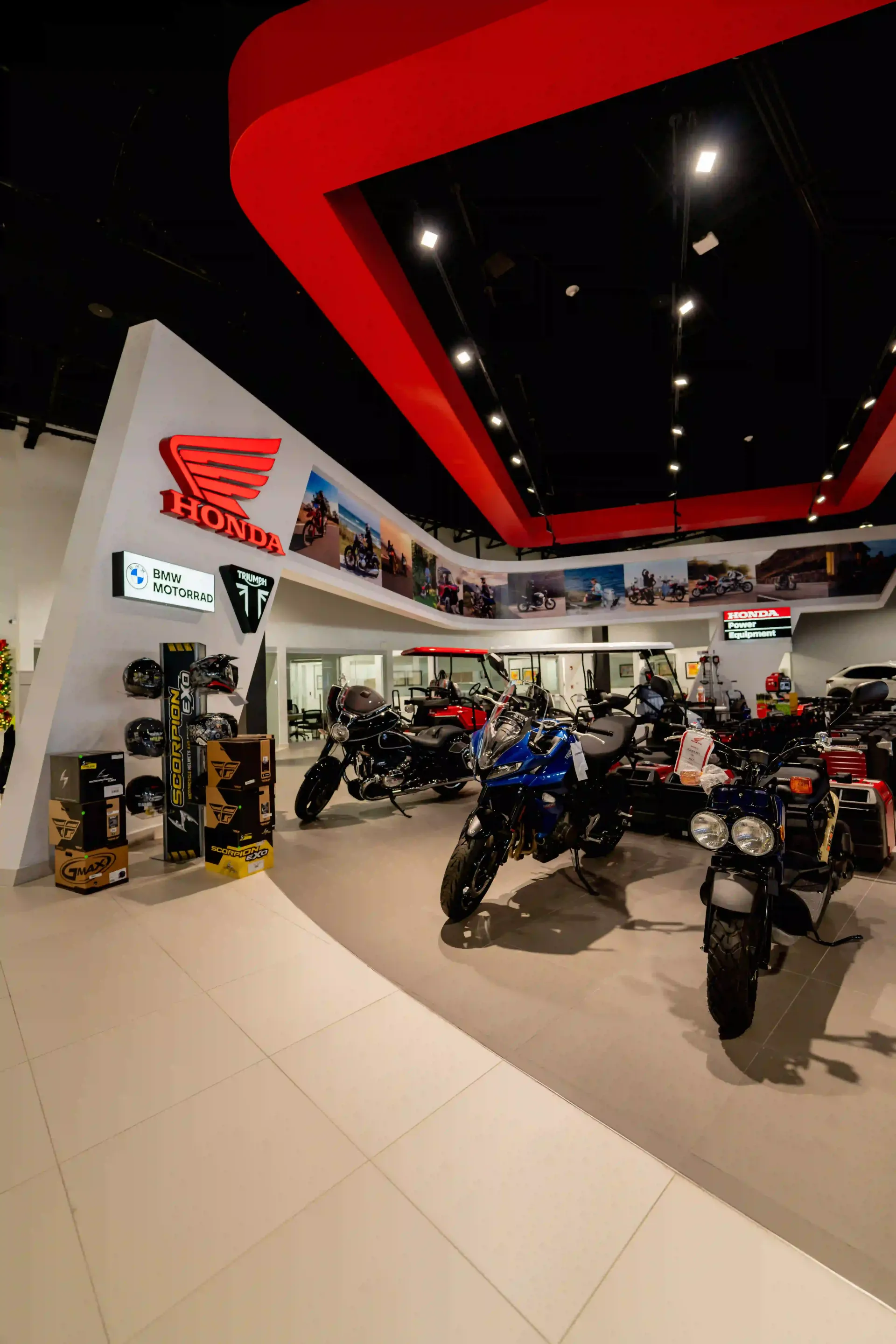 Motorcycle showroom with rows of bikes under black ceiling and red accents
