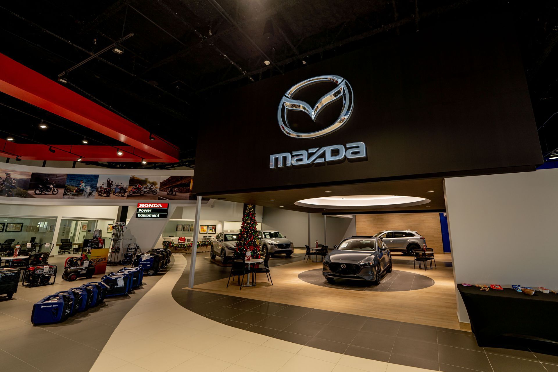 Mazda car showroom with a large logo sign and several vehicles on display