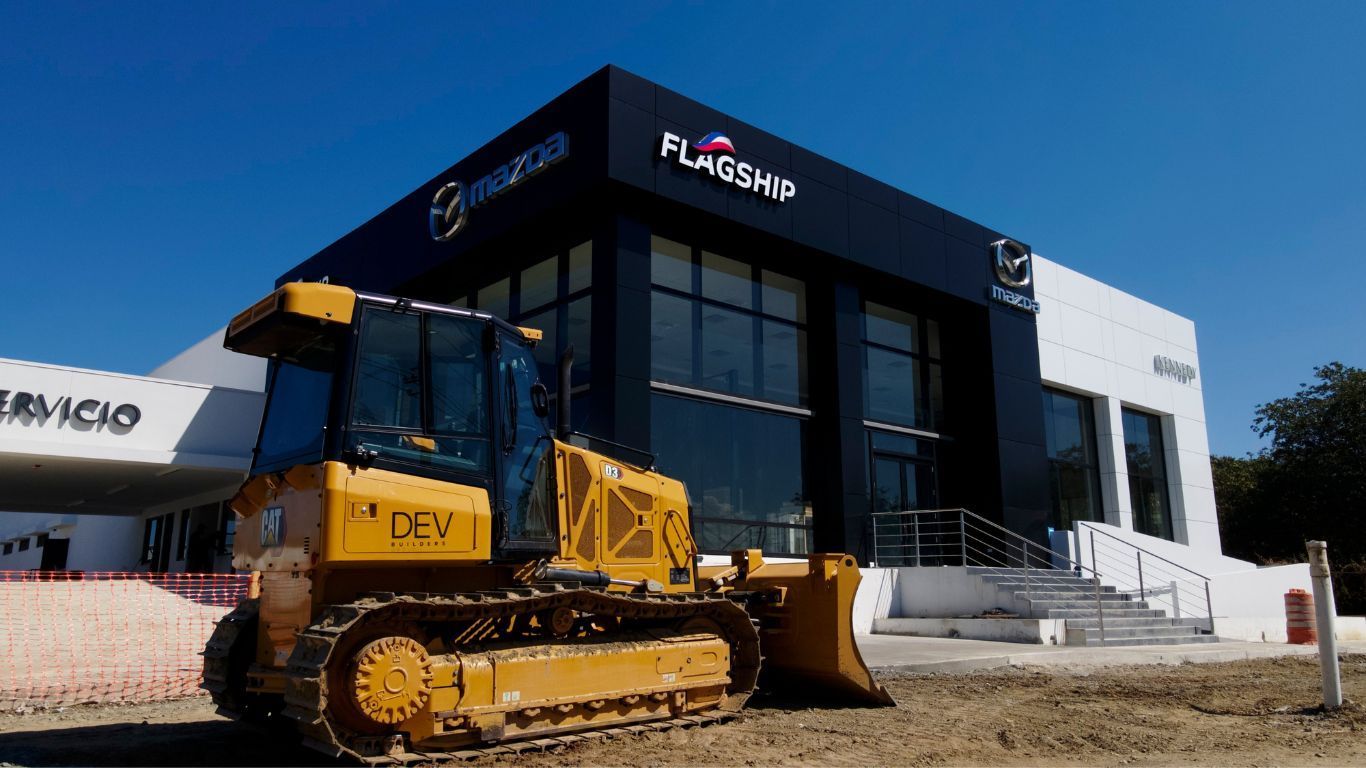 A DEV Builders bulldozer is parked in front of a construction site.