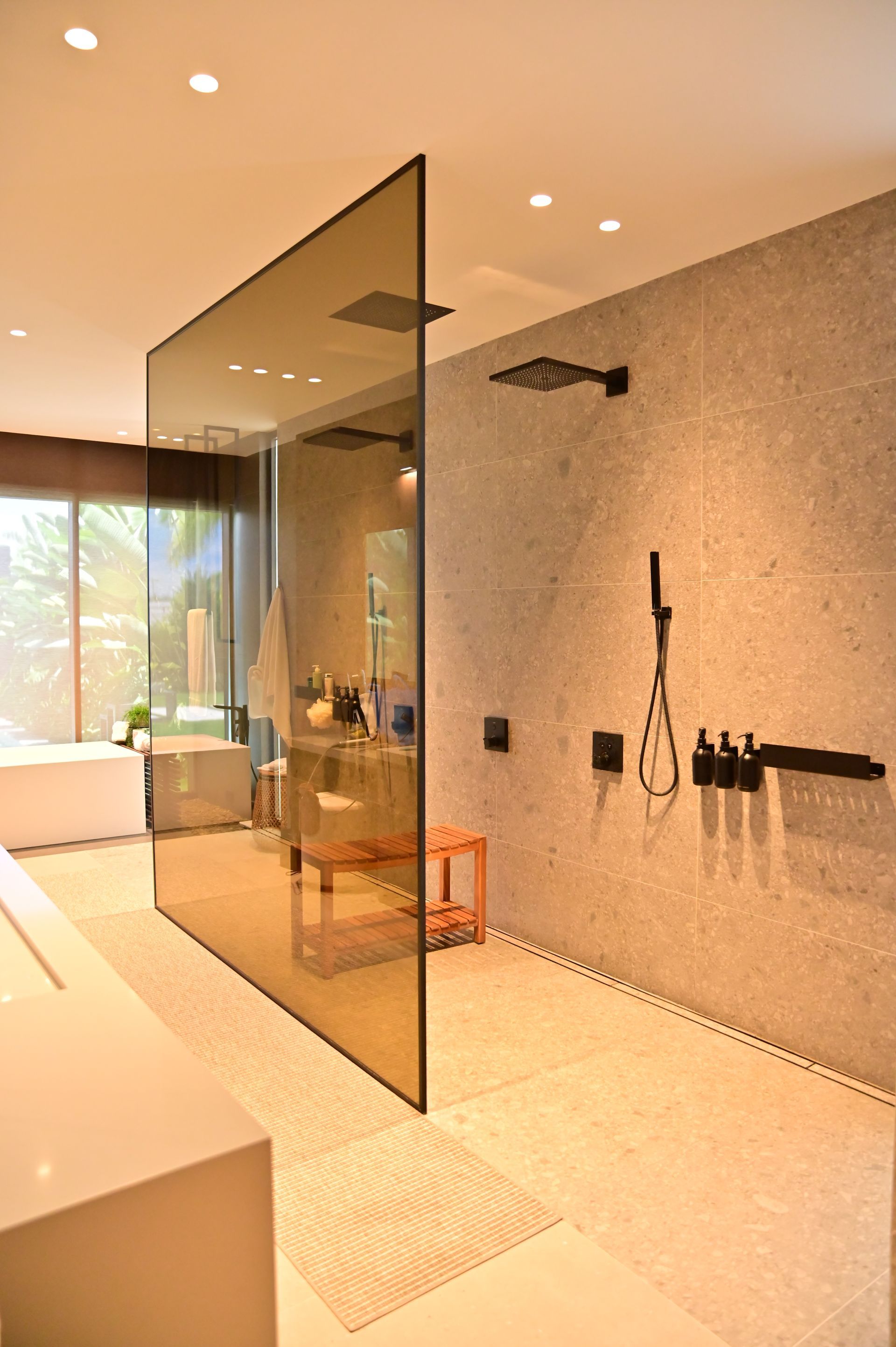 Modern bathroom with glass shower wall, neutral tones.