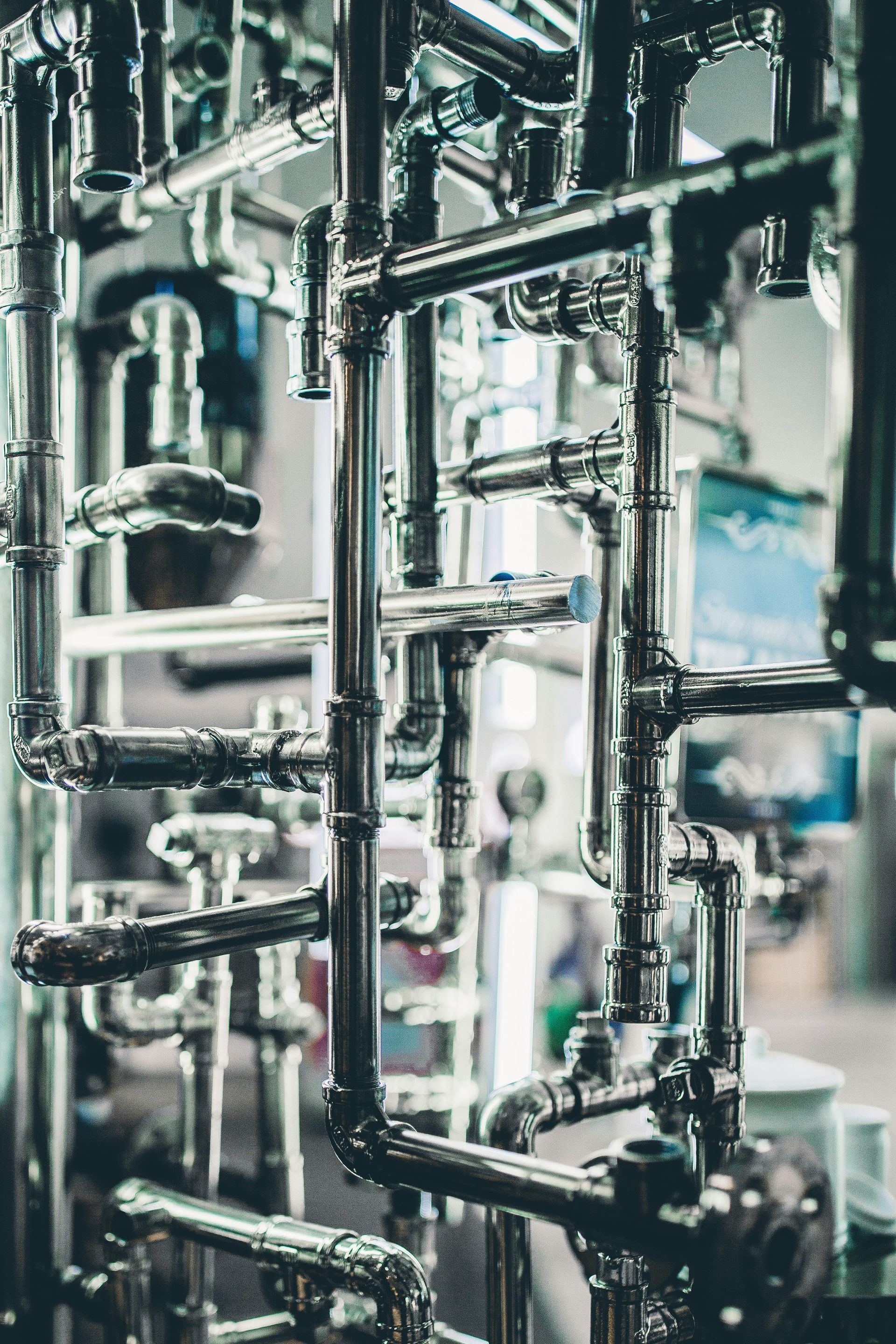 Interlocking stainless steel pipes, tubes, and valves forming a complex industrial network.