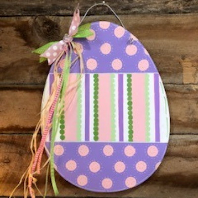 Purple Easter egg-shaped tag with pink polka dots and a striped center, tied with ribbon and twine