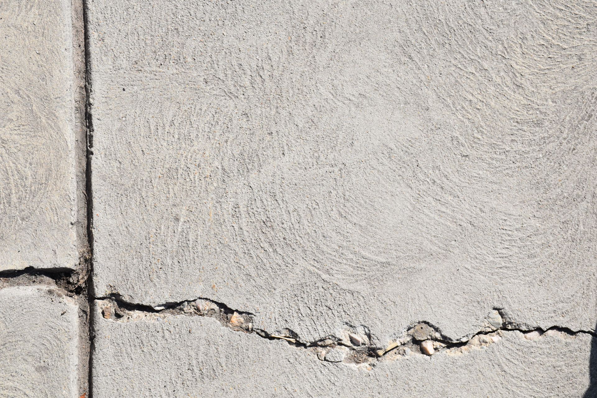 Cracked concrete wall with a horizontal fracture and chipped edges