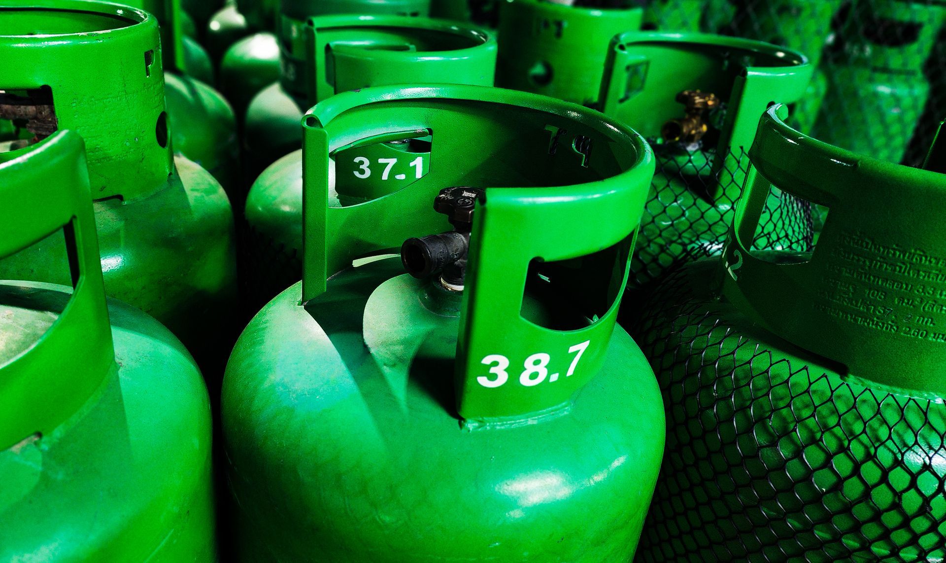 Green propane cylinders stored together, ready for residential and commercial fuel supply.