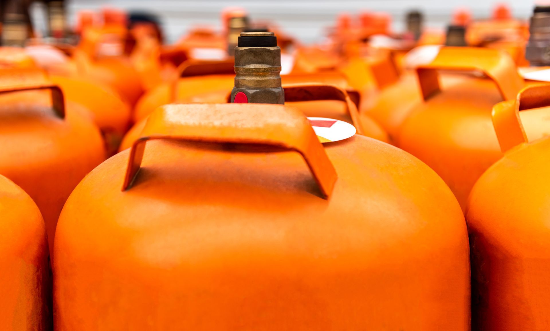 Orange propane cylinders stored in rows, ready for residential and commercial fuel distribution.
