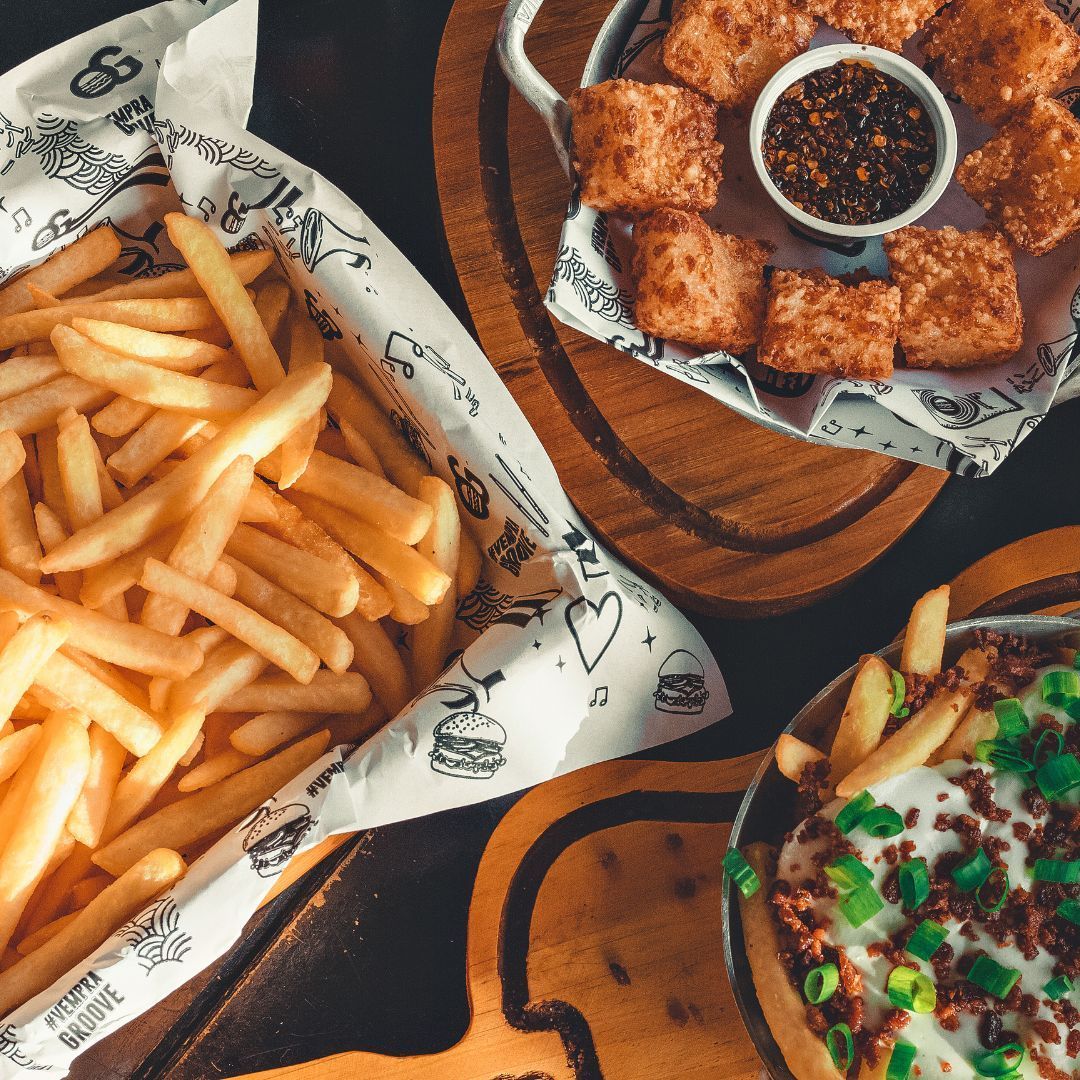 Diet. A table topped with french fries , chicken nuggets , and a pizza.