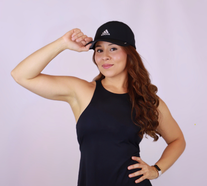 A woman wearing an adidas hat and a black tank top