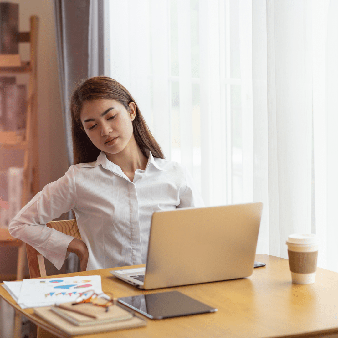 a woman is sitting at a desk using a laptop computer .