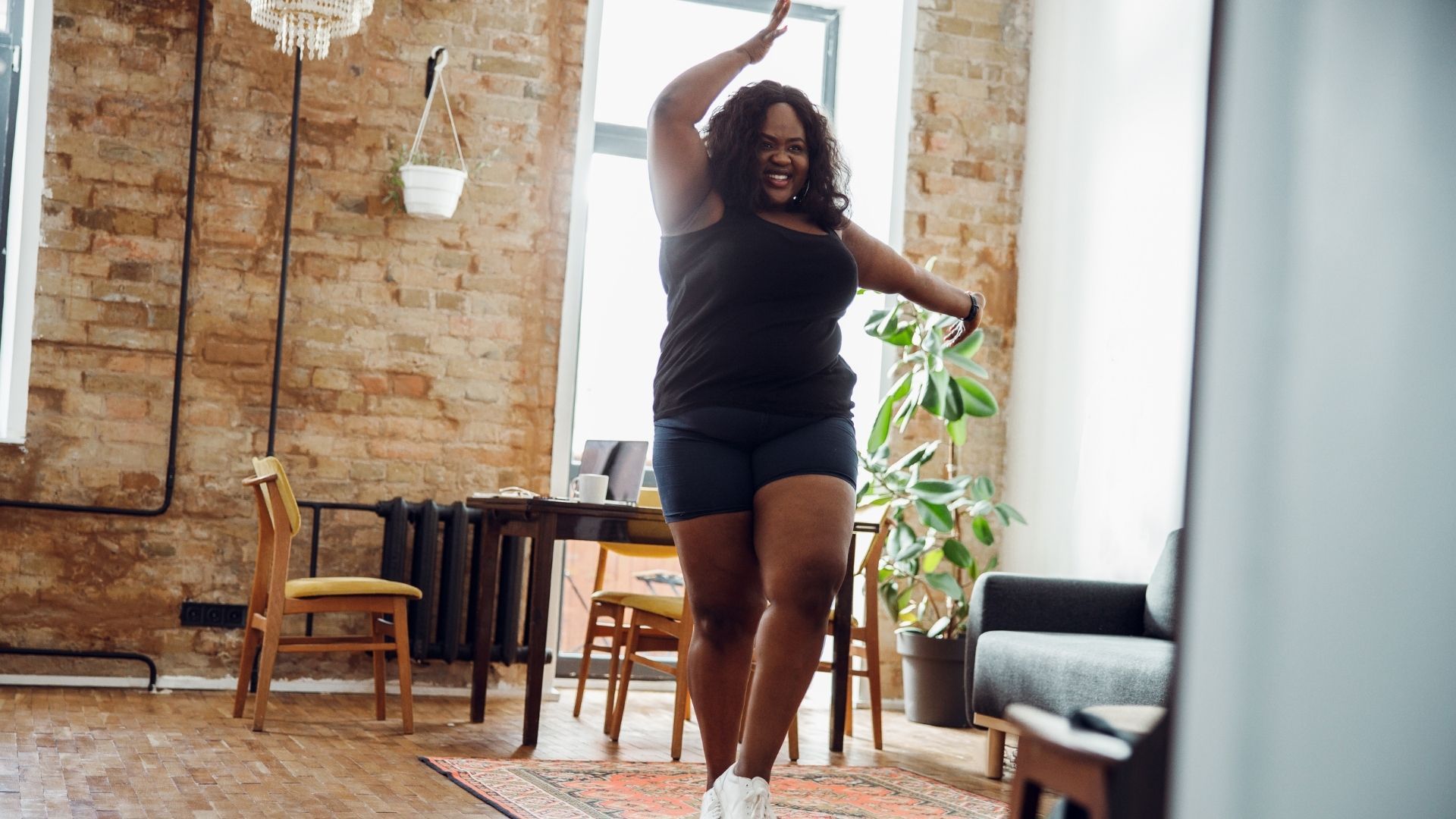 A woman is dancing in a living room.