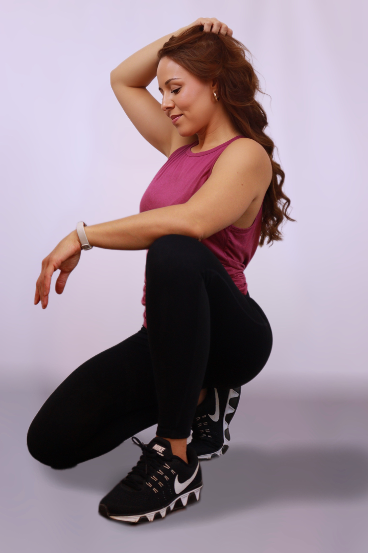 A woman is squatting down wearing nike shoes
