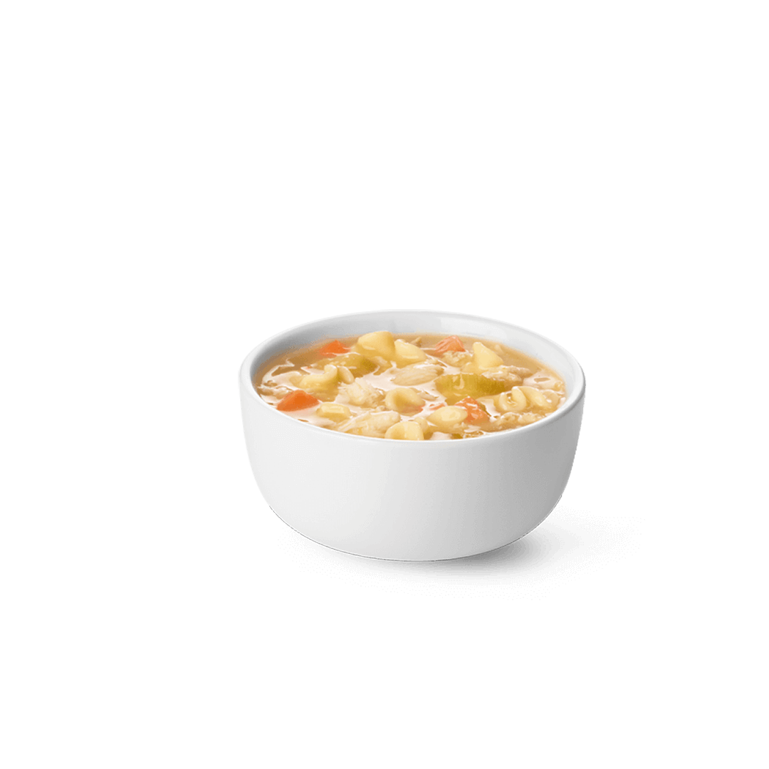 A white bowl filled with chicken noodle soup on a white background. Chick fil A Macros