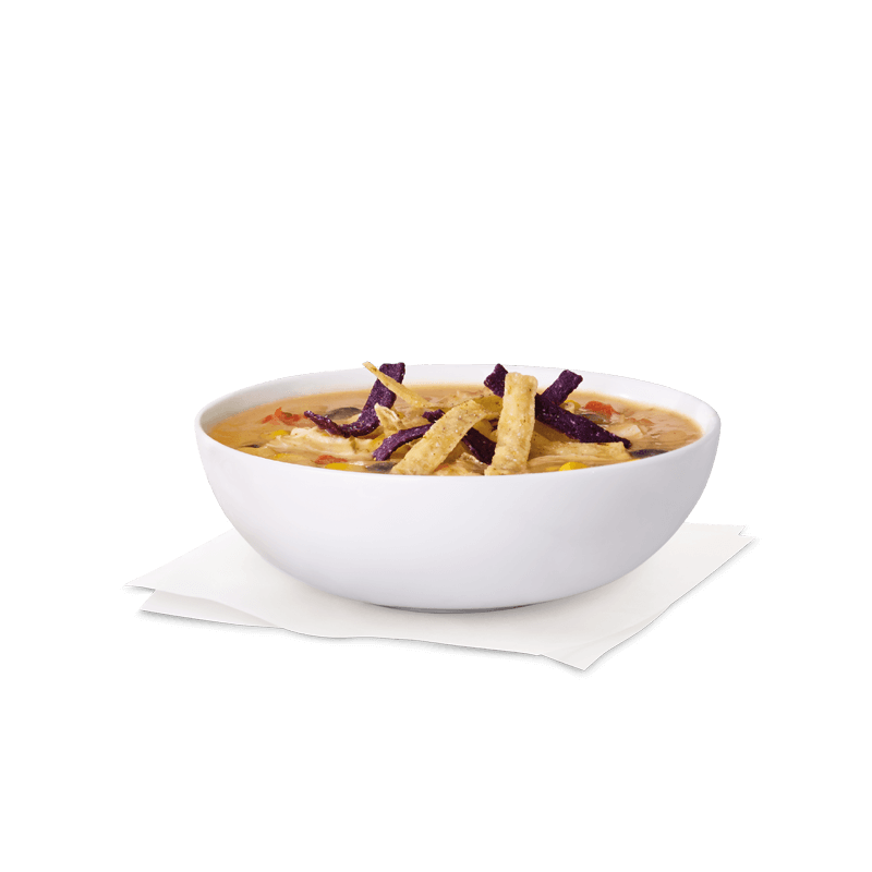 A bowl of soup with tortilla strips on a napkin on a table. Chick fil A Macros