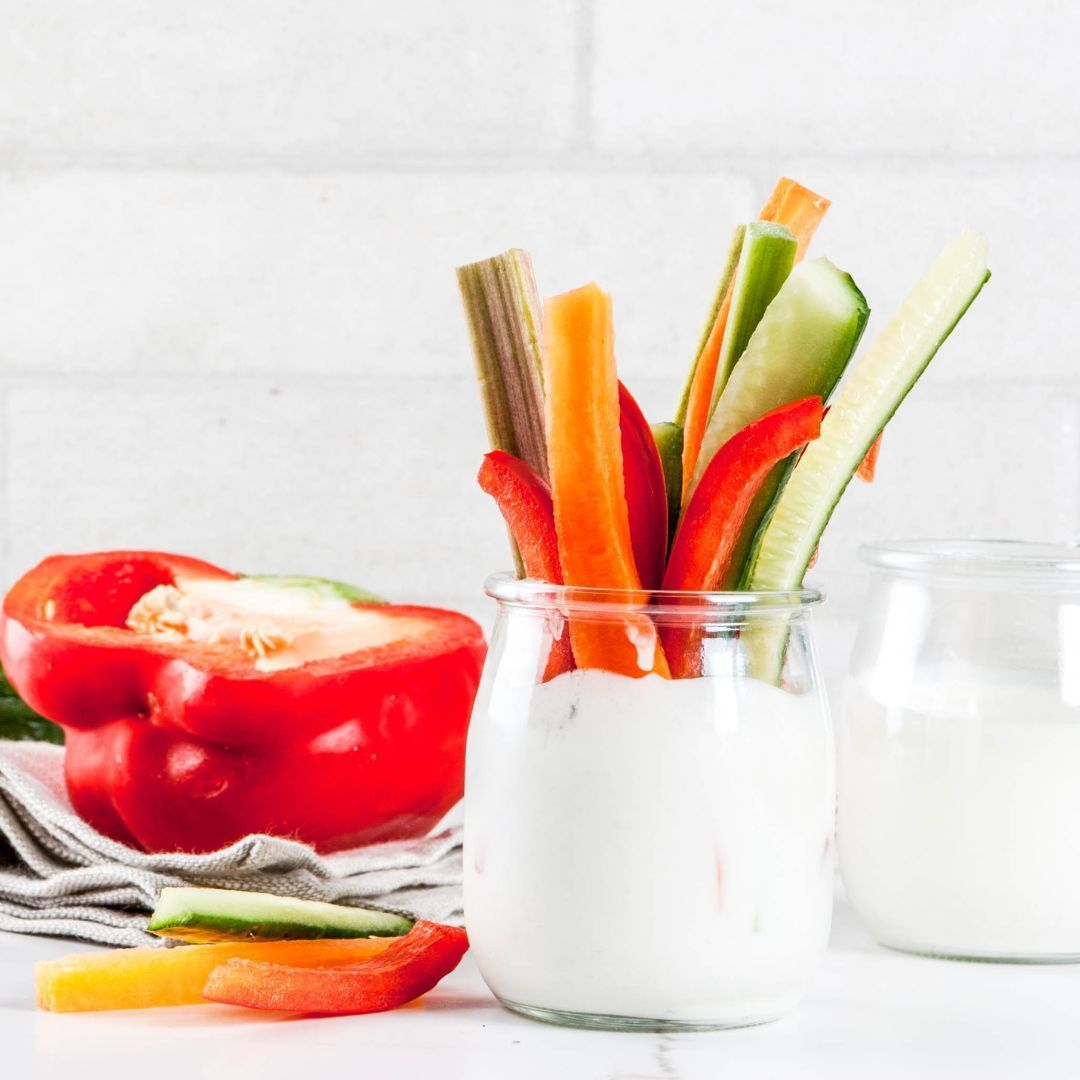 A jar of yogurt with vegetables in it