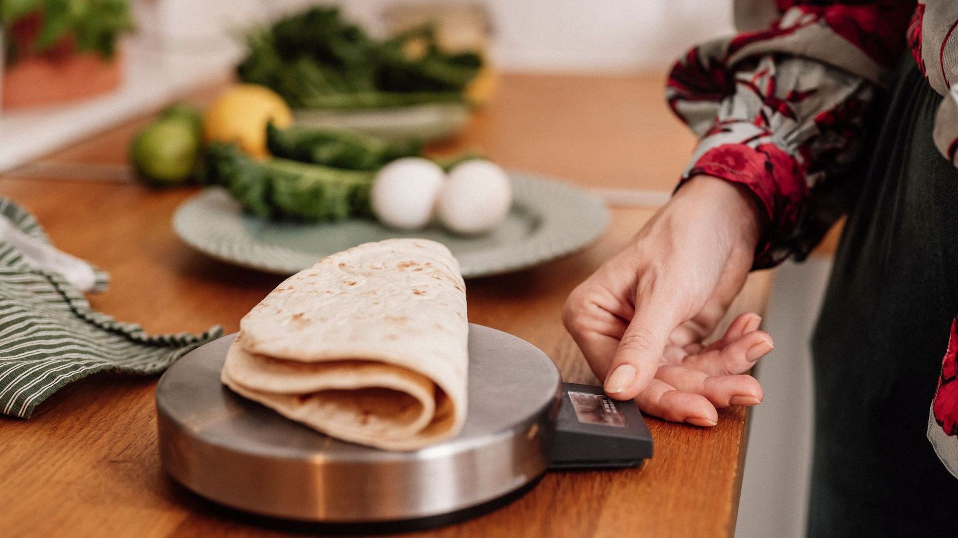 A person is weighing a tortilla on a scale.