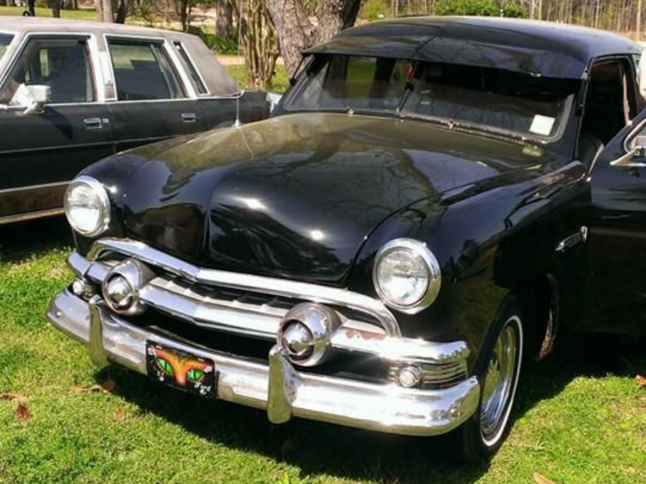 Classic black vintage car parked on grass beside another old car in rocky mount nc
