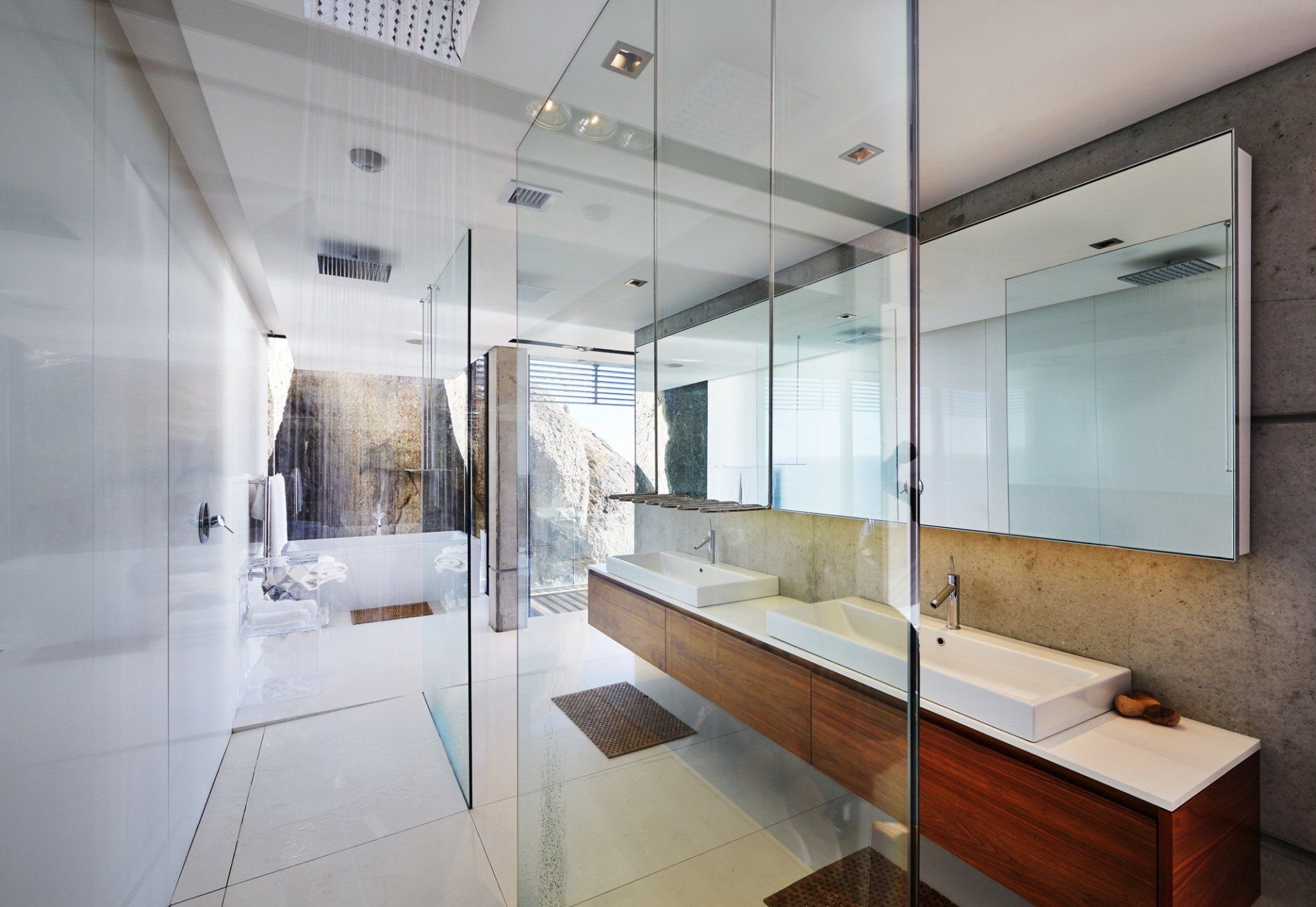 Contemporary bathroom with frameless glass shower enclosure, wooden vanity, and large mirror