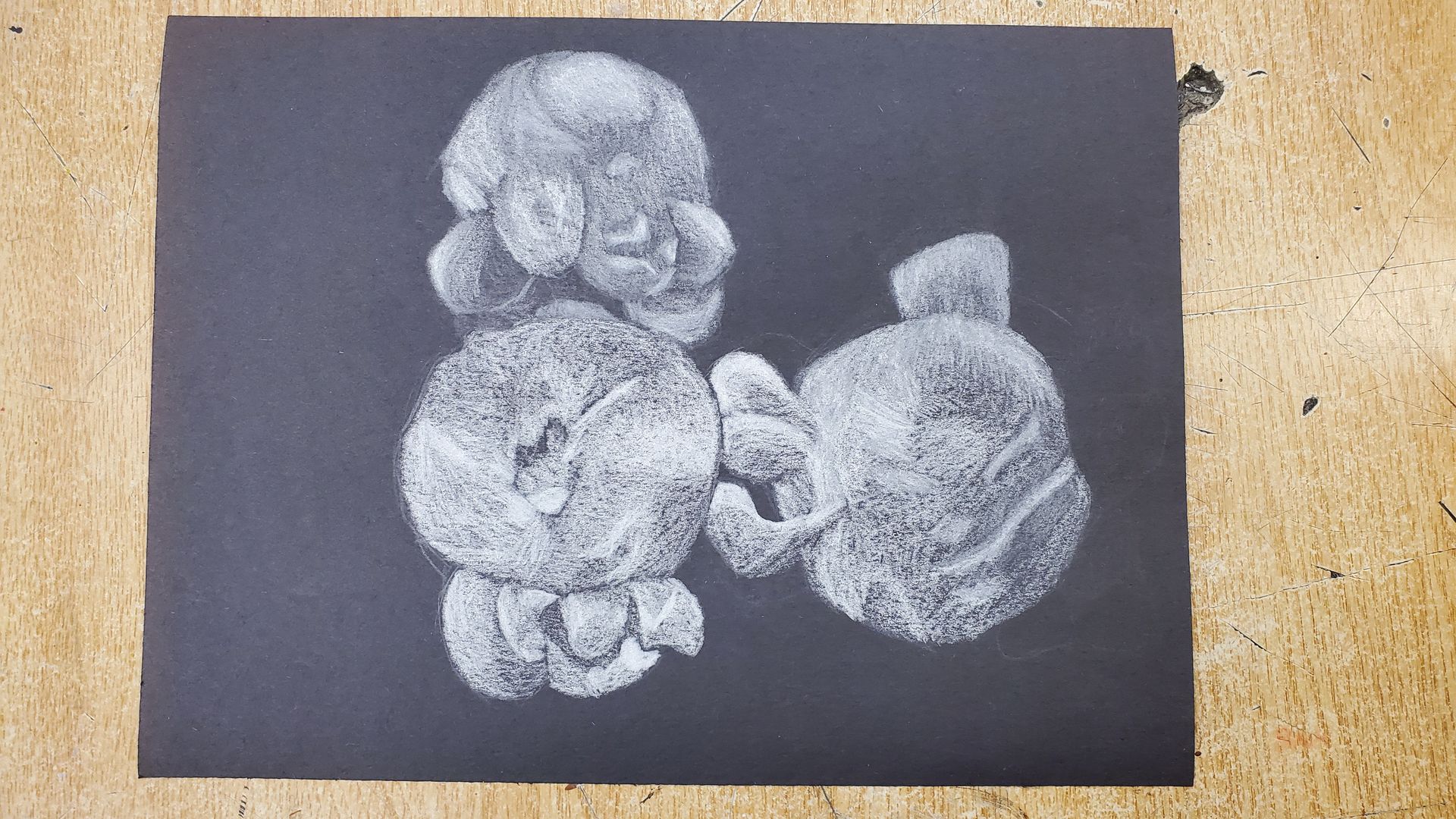 Three pieces of white popcorn drawn on black paper.
