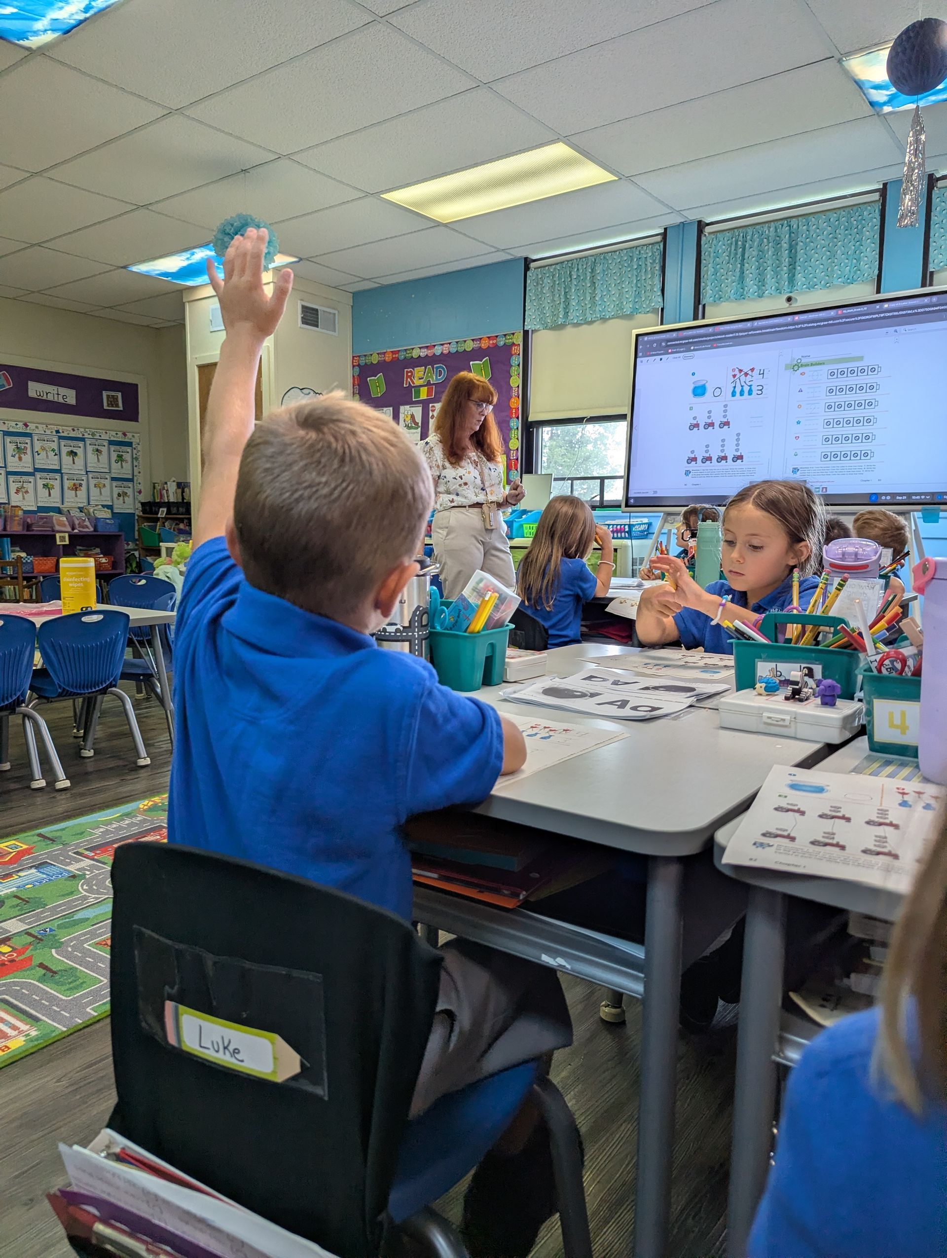 A group of children are playing with red cups on a table.