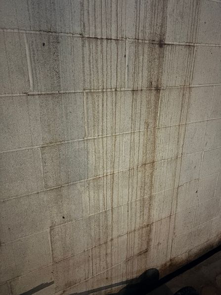 Stained concrete wall with vertical water marks and dark damp streaks near the bottom | Lancaster, PA Stained concrete wall with vertical water marks and dark damp streaks near the bottom | Lancaster, PA