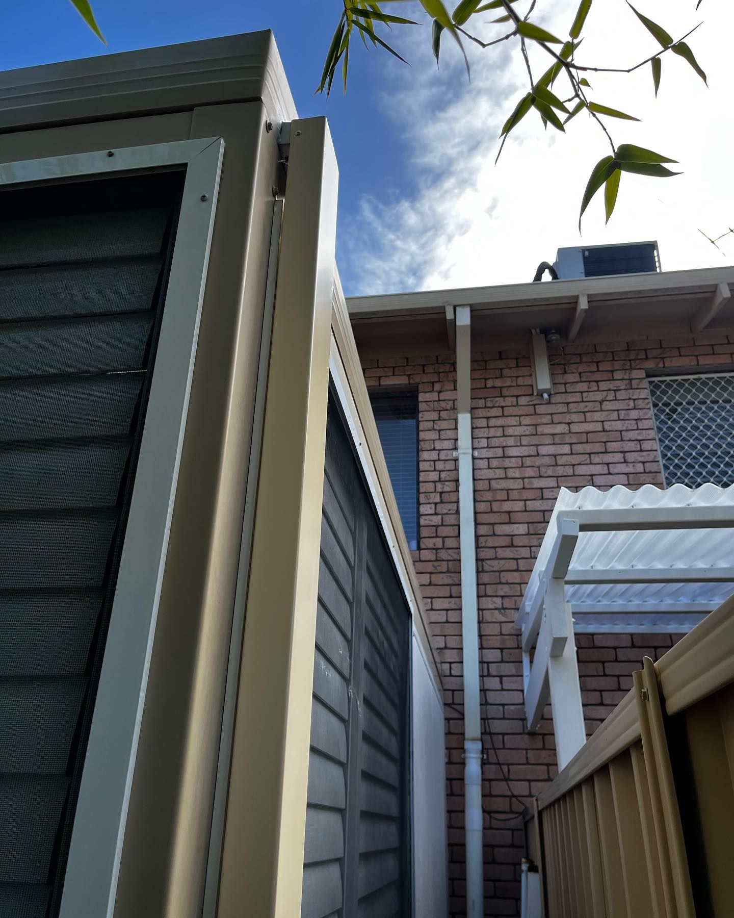 Looking up at a brick building with a white roof