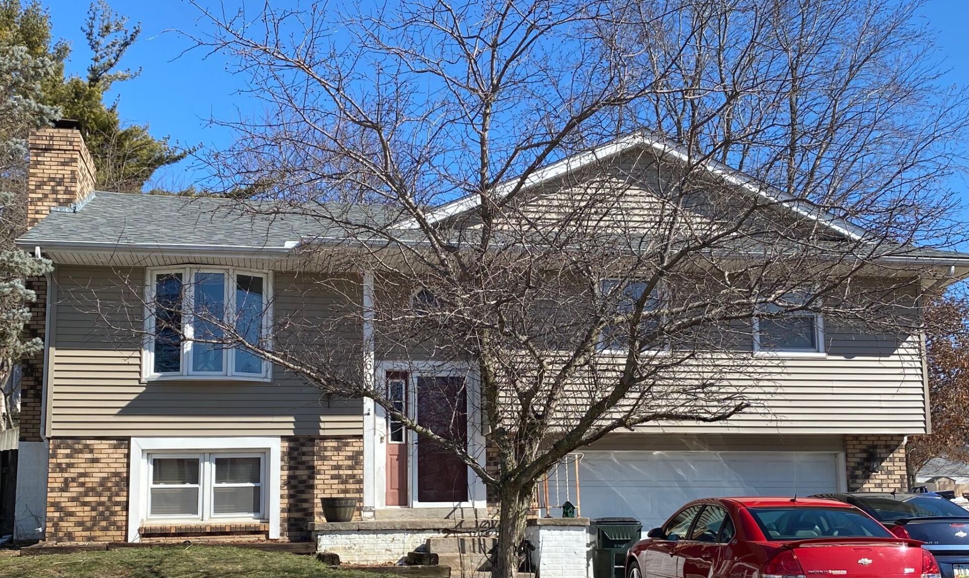 A house with a red car parked in front of it
