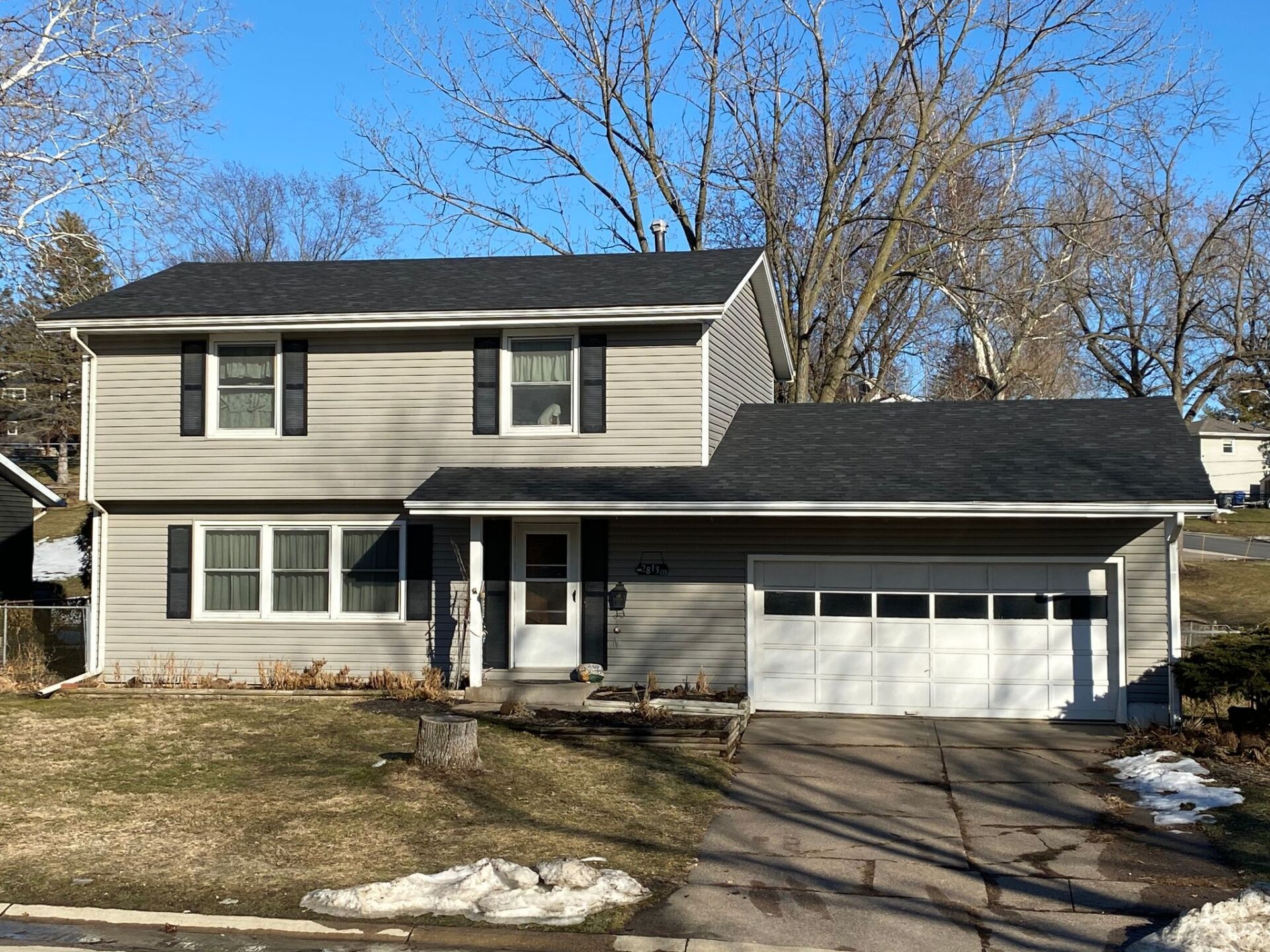 A large house with a black roof and a white garage door.
