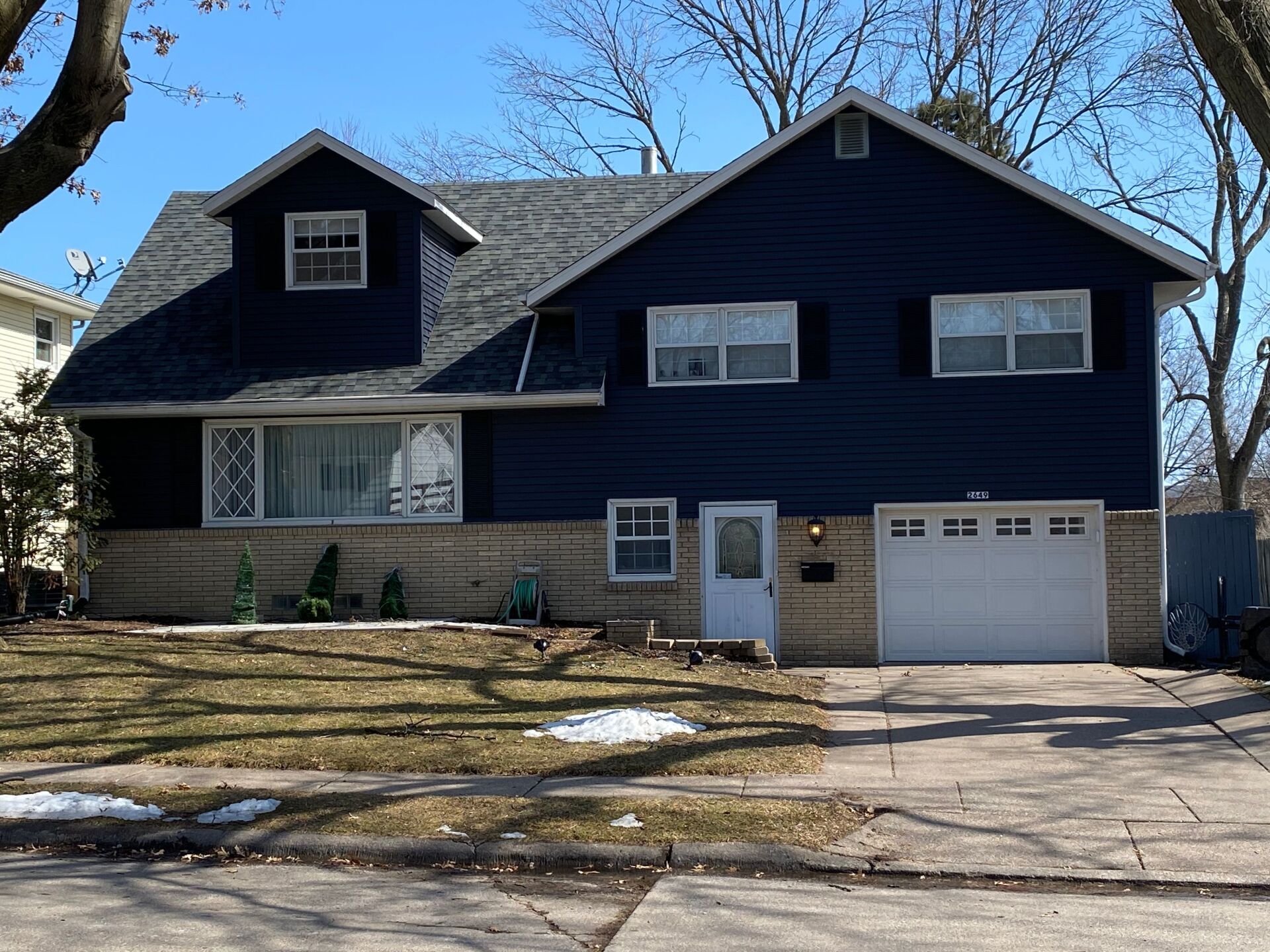 A large blue house with a white garage door