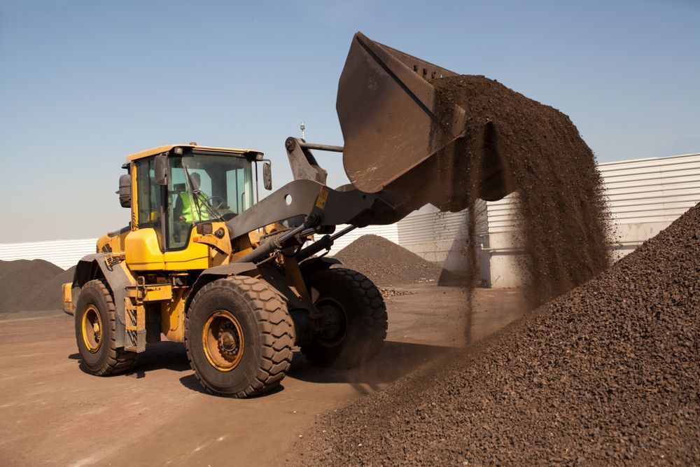 A Bulldozer is Loading Dirt Into a Pile of Dirt — Rowdraulics NQ Pty Ltd In Mount Louisa, QLD