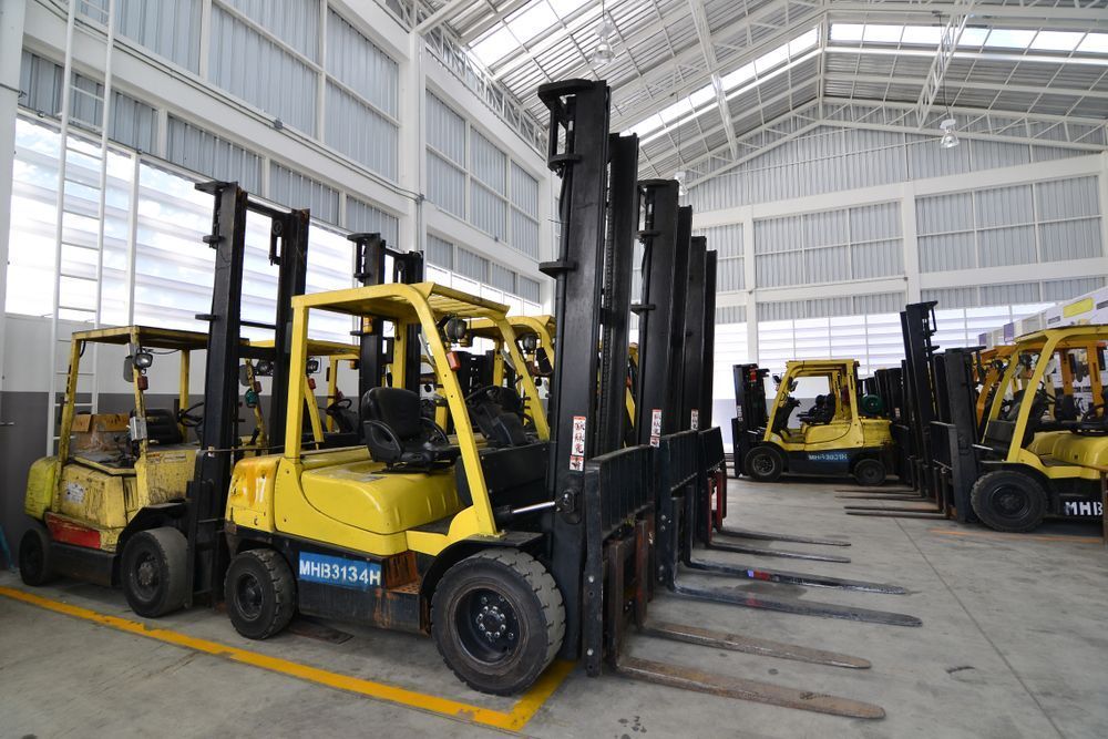 A Row of Forklifts Are Parked in a Warehouse — Rowdraulics NQ Pty Ltd in Mount Louisa, QLD