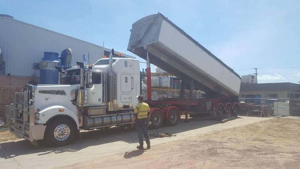 A Man is Standing Next to a Large Semi Truck — Rowdraulics NQ Pty Ltd in Mount Louisa, QLD