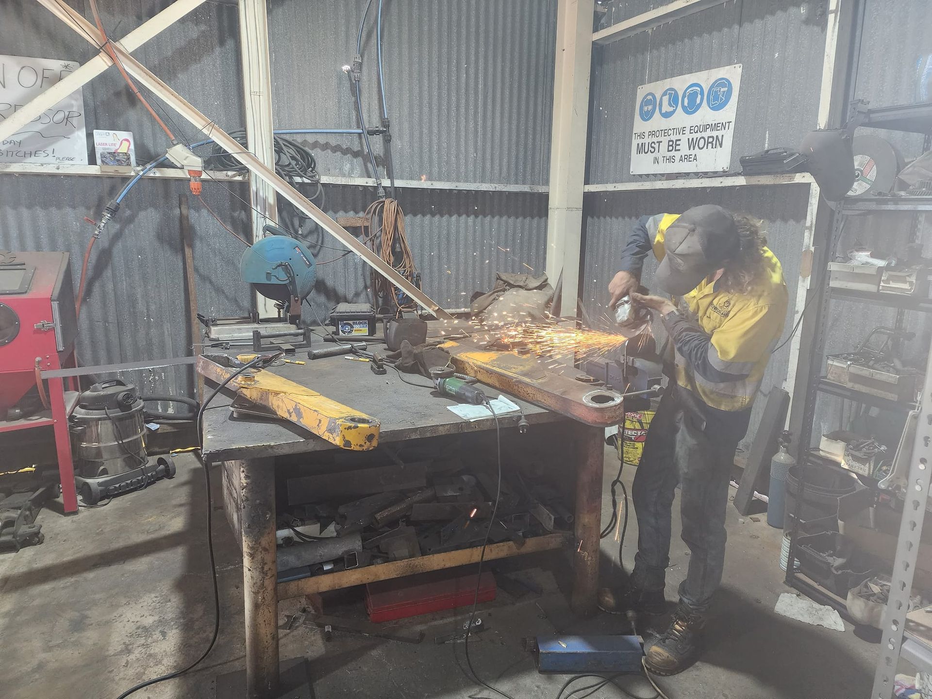 Man Working On A Part Of Excavator In A Workshop — Rowdraulics NQ Pty Ltd in Mackay, QLD