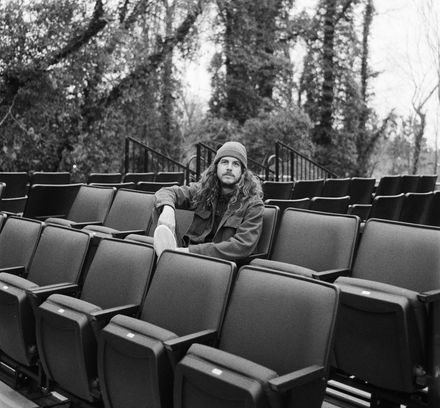 Photo of C.J. Strehlow, the co-founder of the production company C-Roll Productions, sitting in venue seats