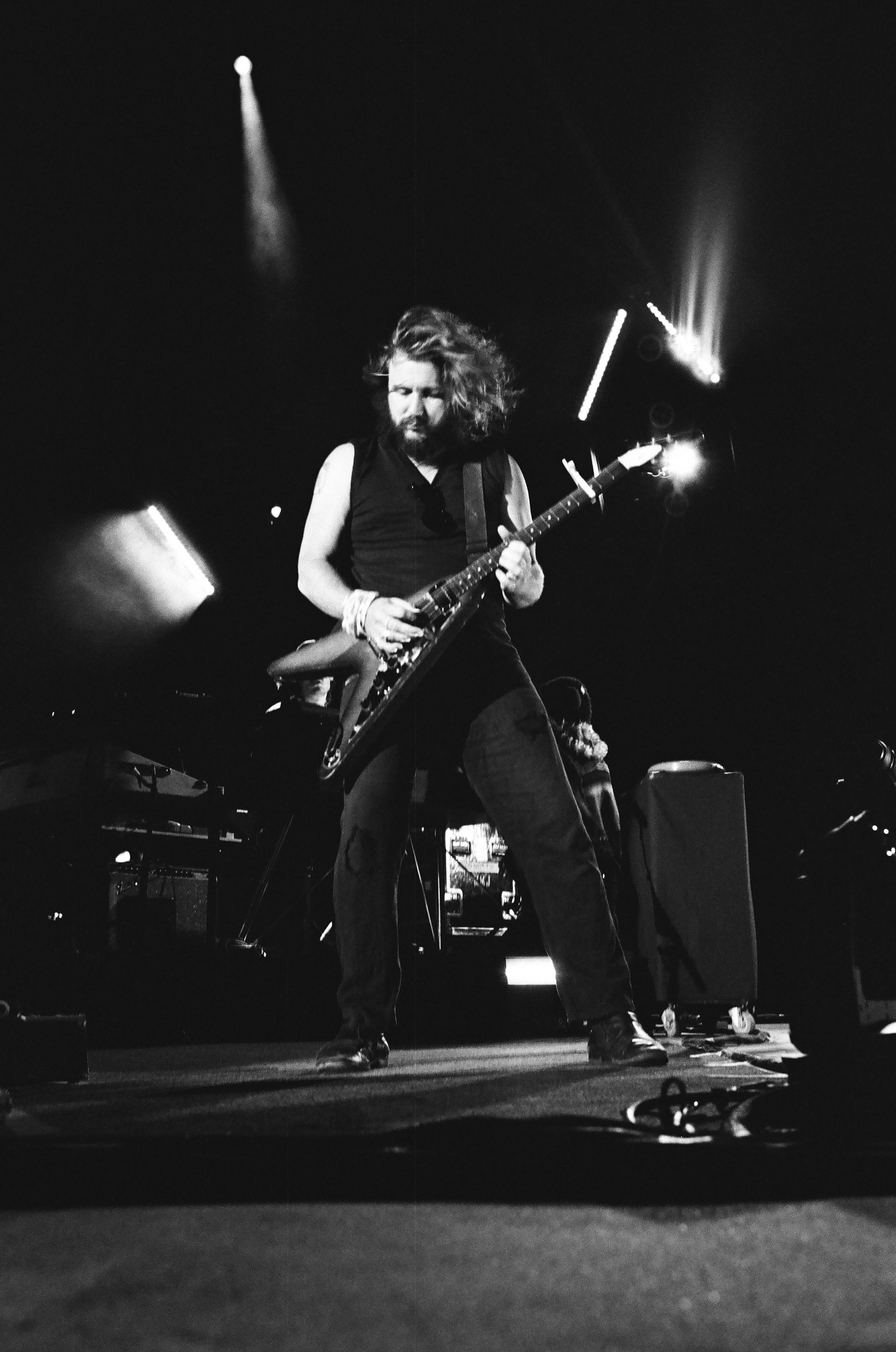 A black and white photo of a man playing a guitar on stage