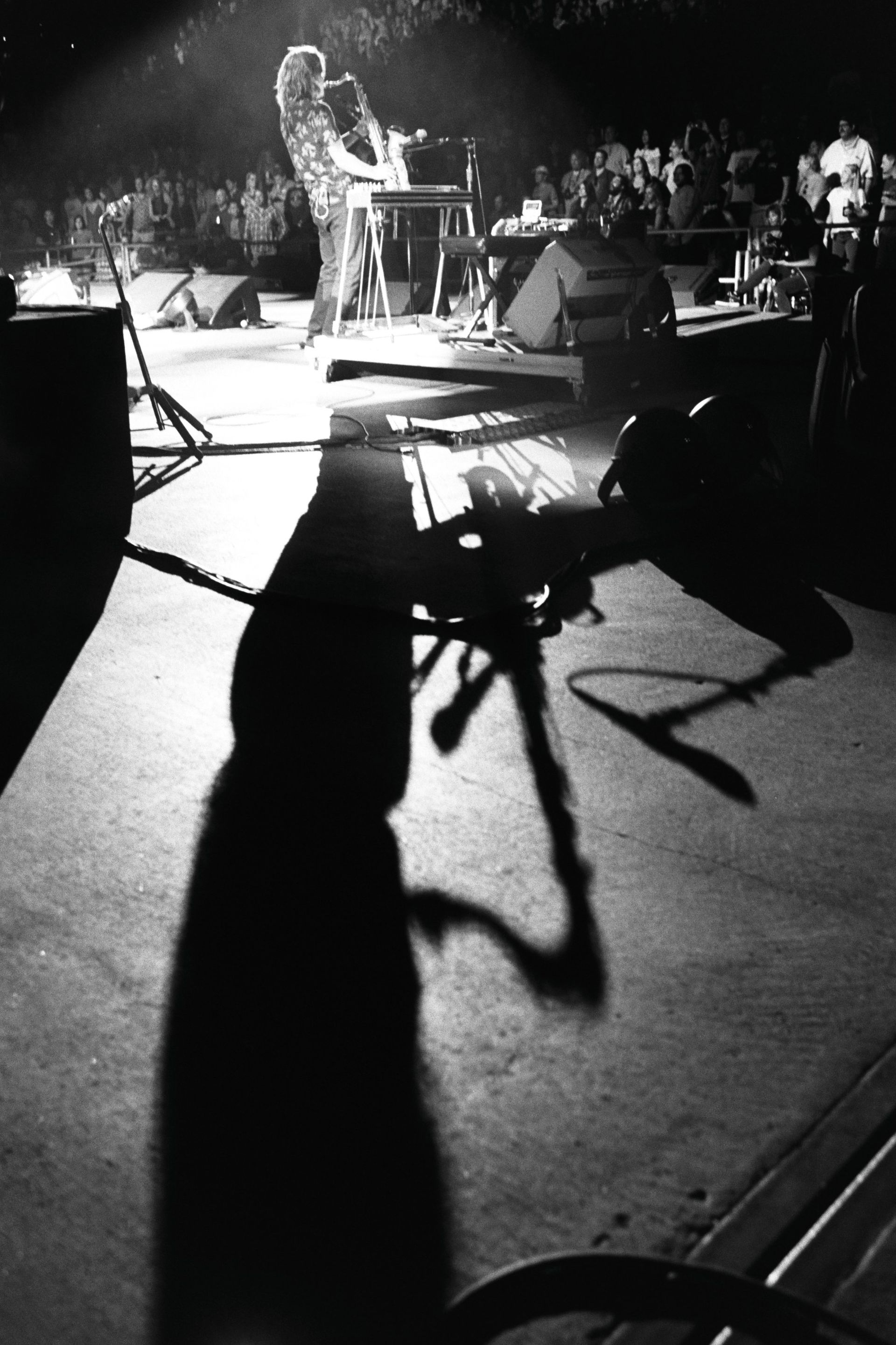 A shadow of a person playing a saxophone on a stage