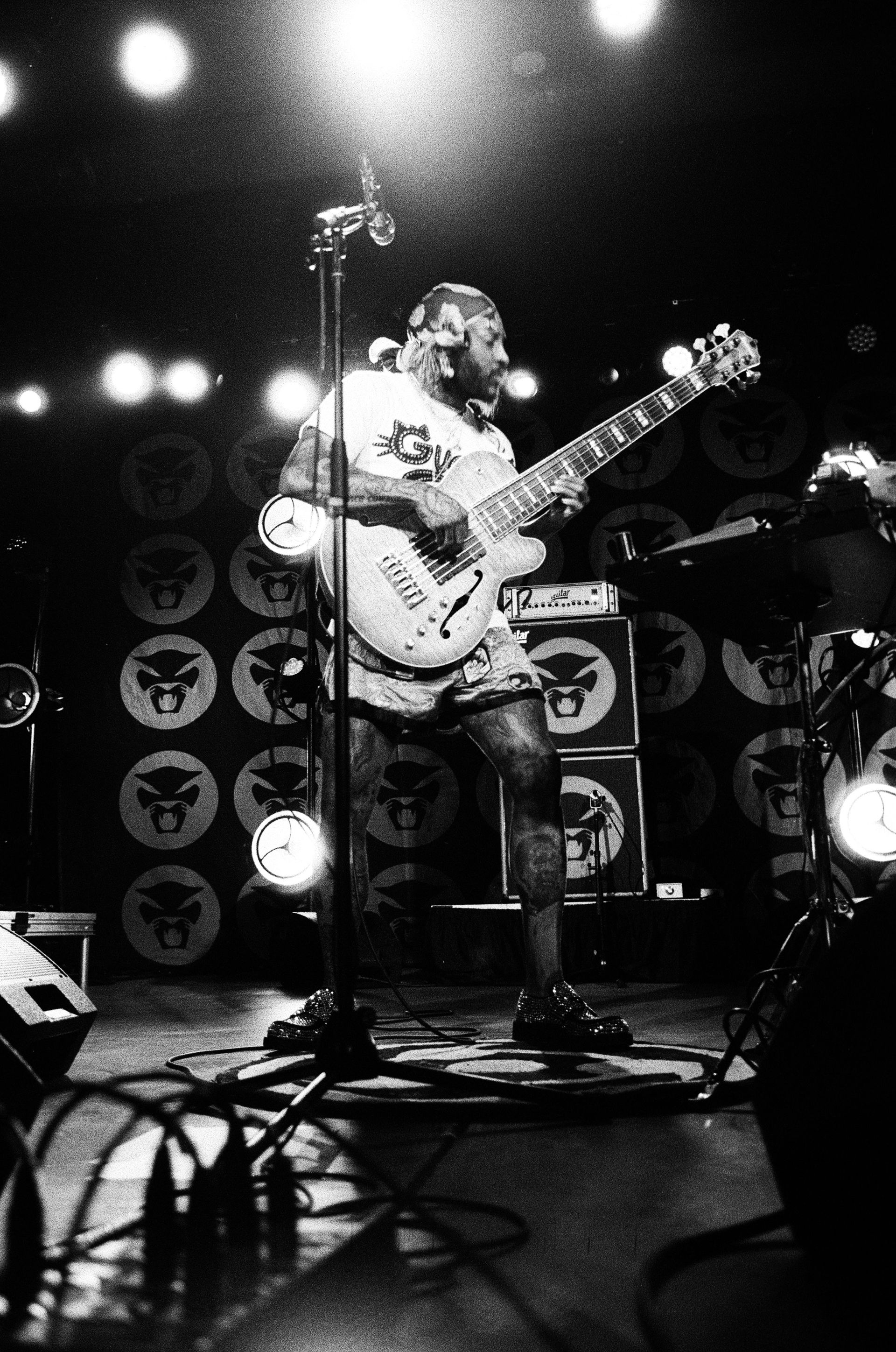 A man is playing a guitar and singing into a microphone on a stage.