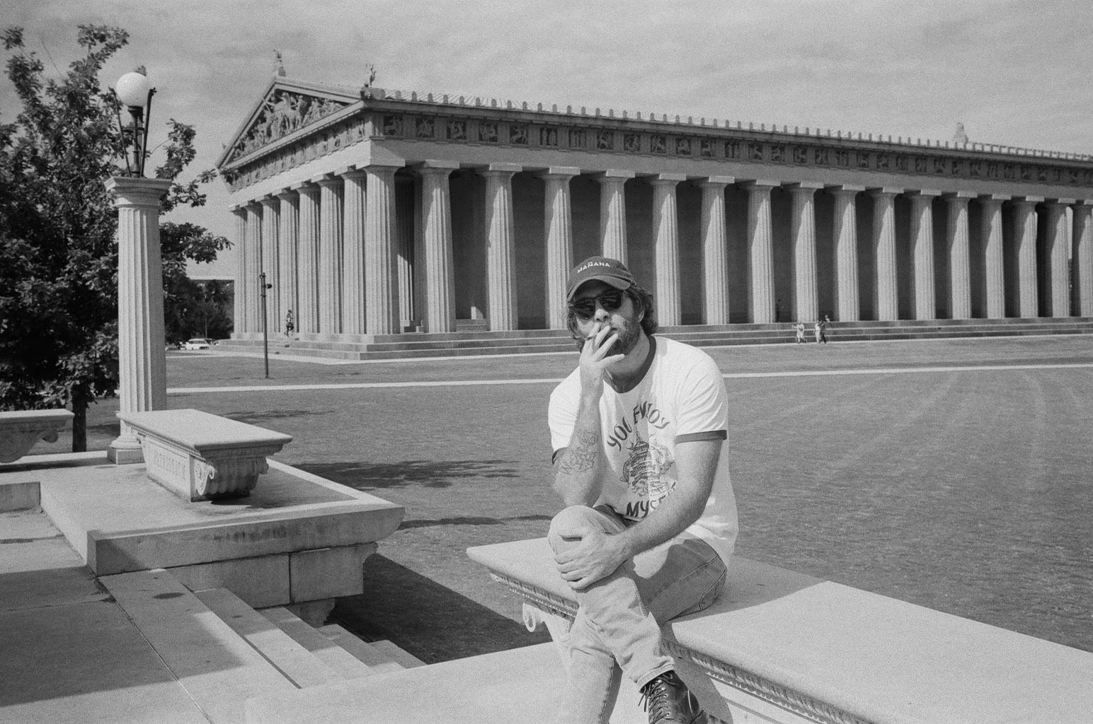 A man sitting on a bench in front of a building