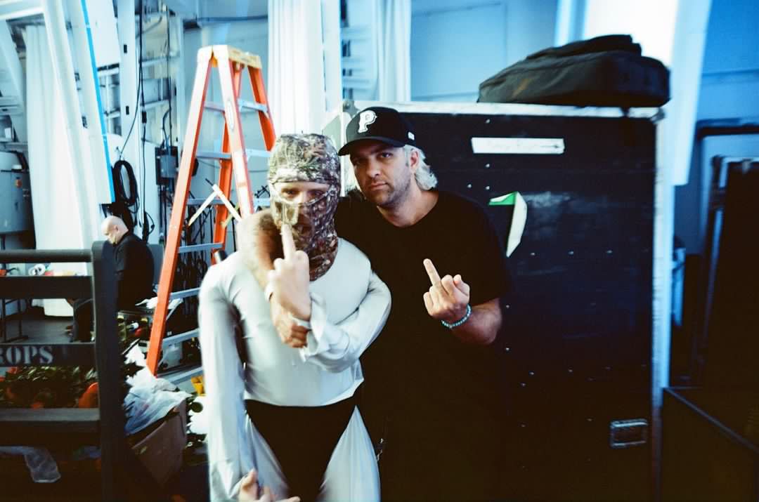A man and a woman are posing for a picture and the woman is wearing a mask.