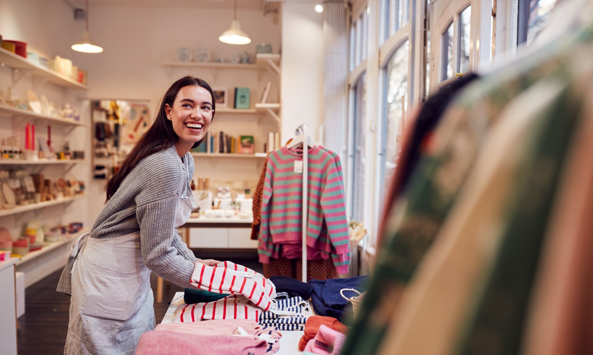 A woman is working in a clothing store.