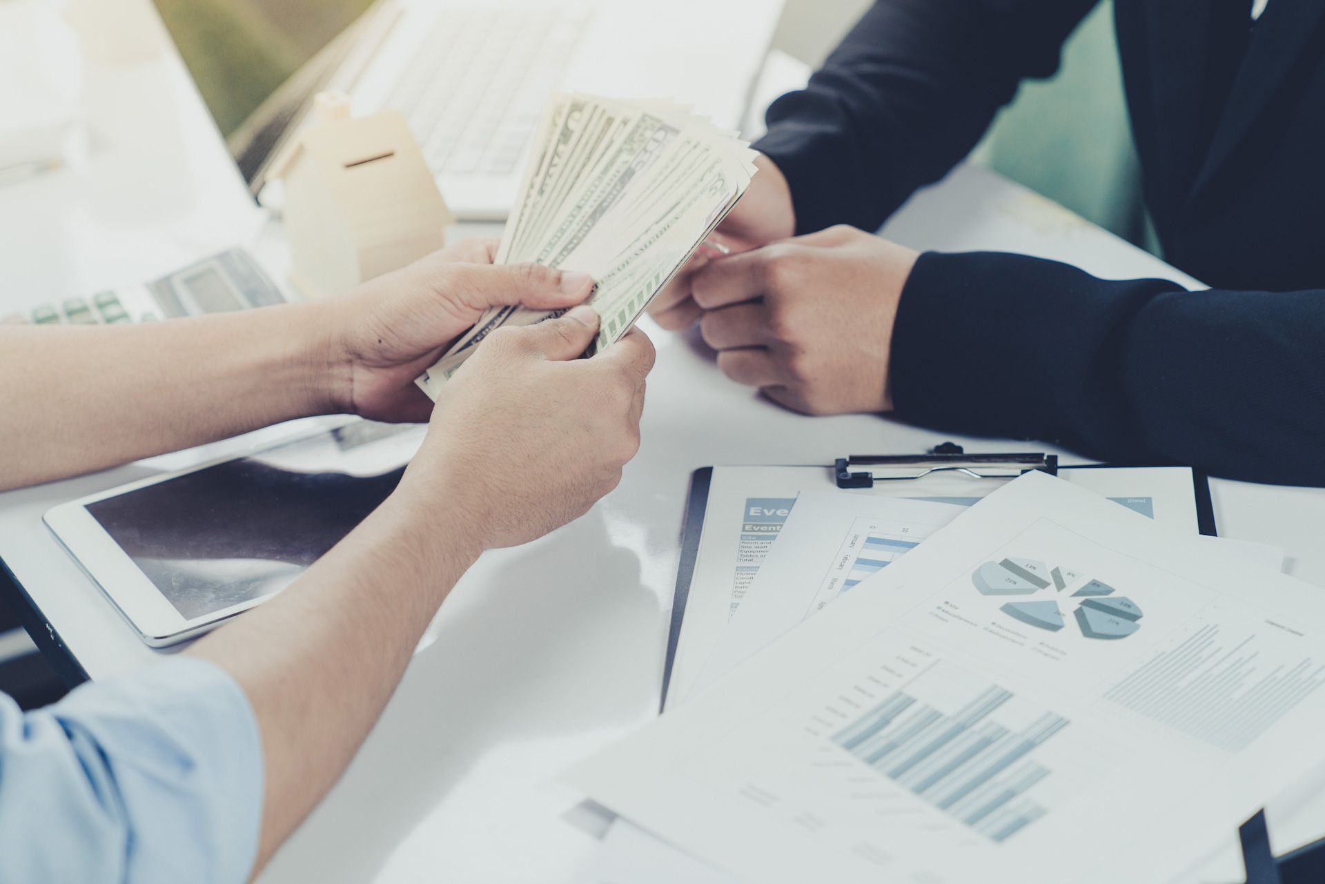 A man is handing a woman a stack of money.