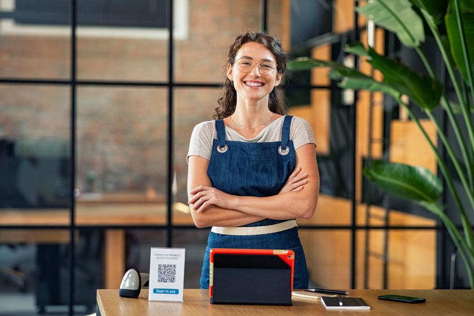 A woman is standing in front of a counter with her arms crossed.