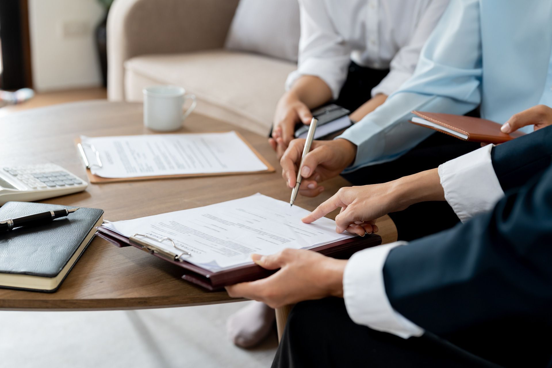 A group of people are sitting at a table signing a document.