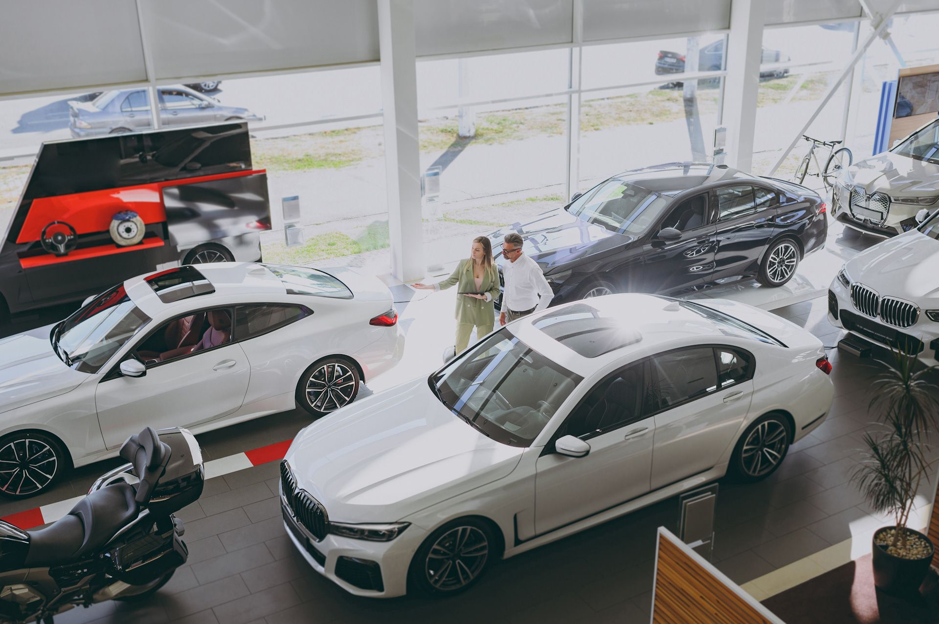 A couple is looking at a car in a showroom.