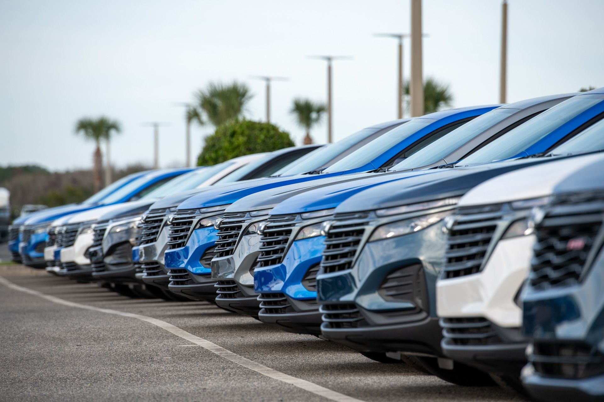 A row of cars parked next to each other in a parking lot.