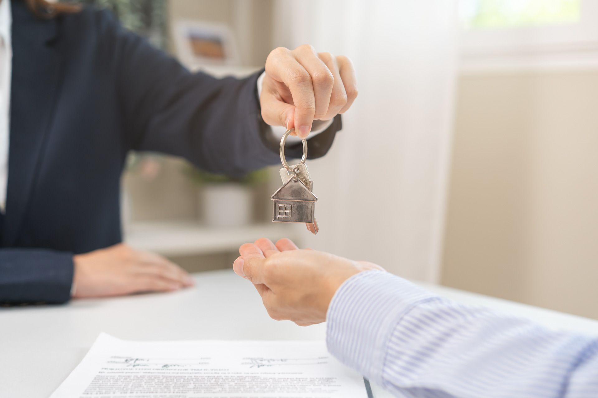 A person is giving a house key to another person.