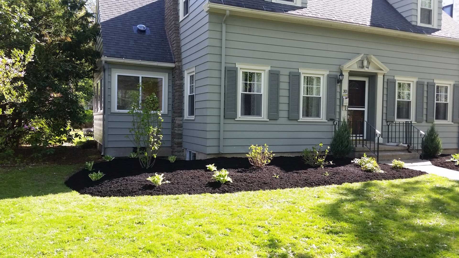 back of gray house with landscaping